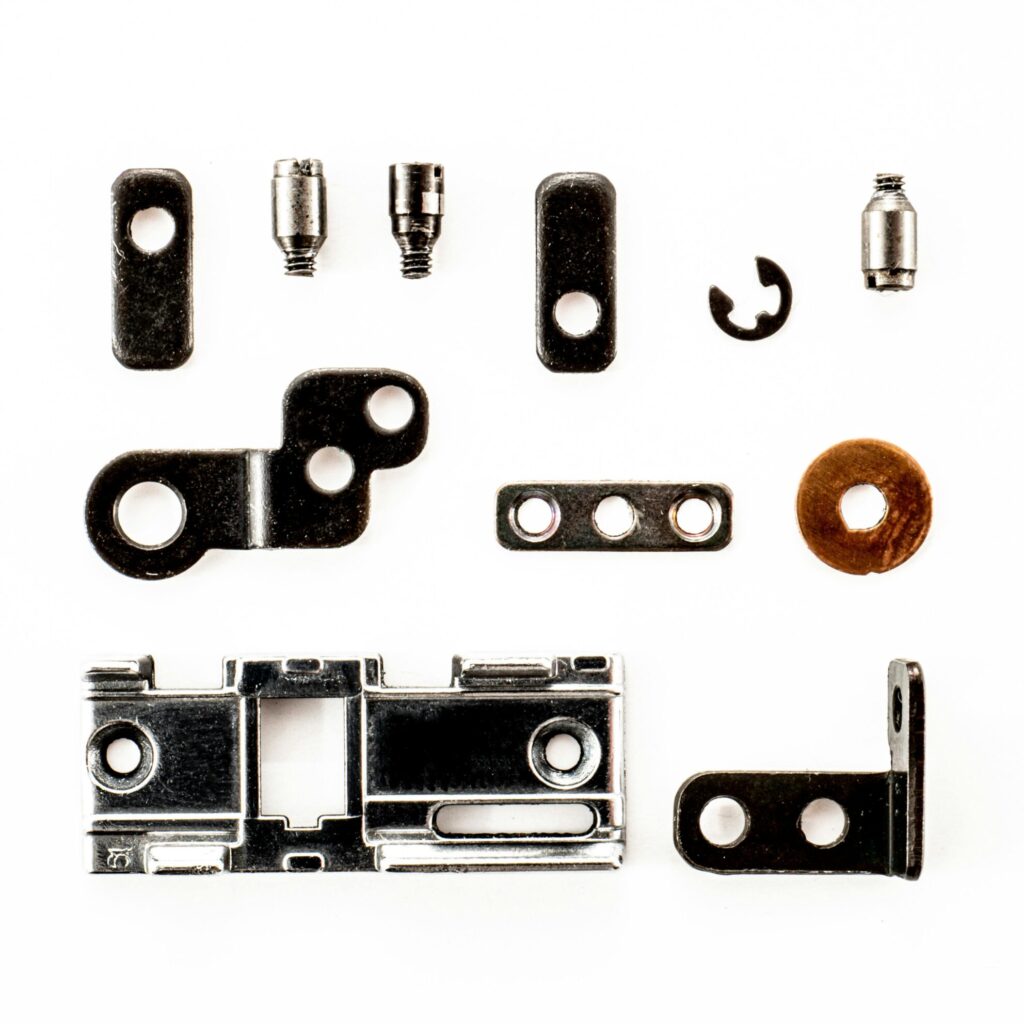 A top view of various metal fasteners arranged on a white background.